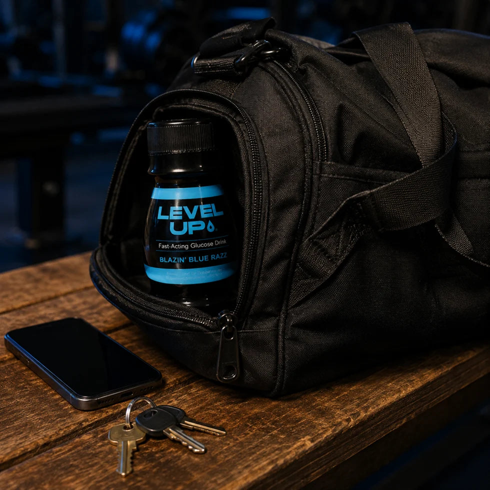 LEVEL UP bottle tucked in the side pocket of a gym bag on a wooden bench